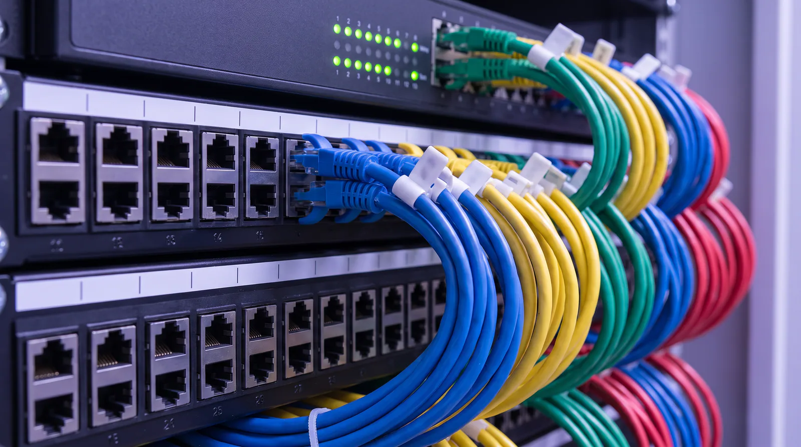 A structured cabling patch panel with colour-coded, labelled patch cords